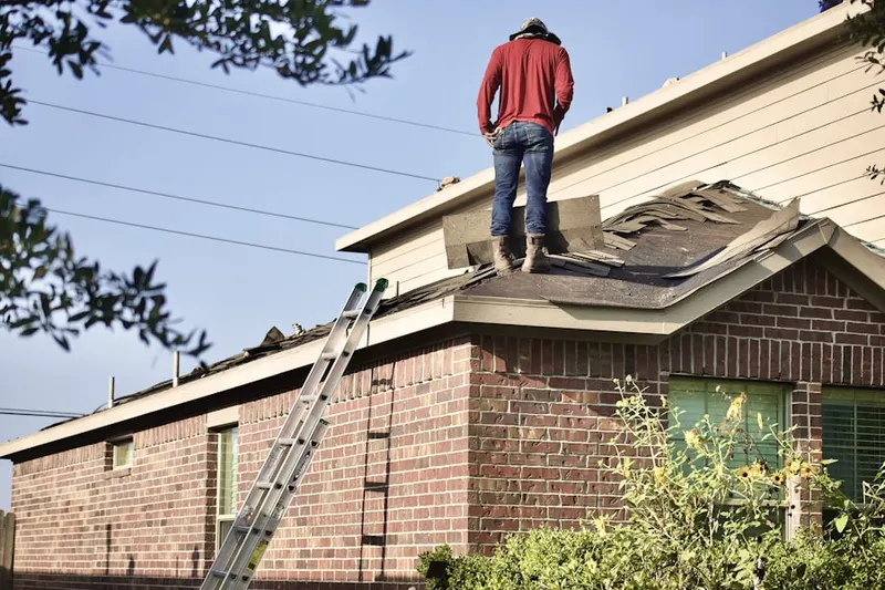 Professional roofer working on a residential roof in South Manor